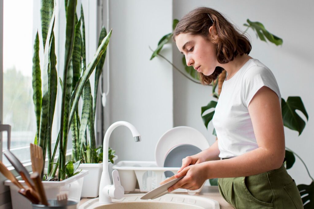 Side view young woman washing dishes